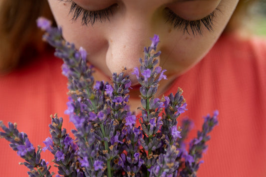 woman in orange shirt with purple flowers on her head