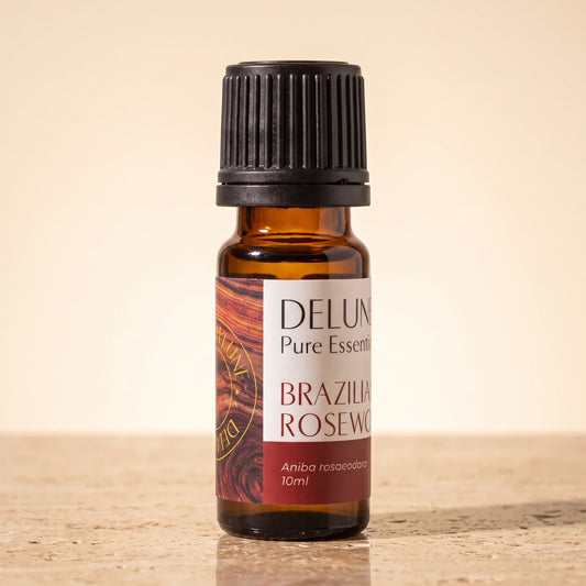 Delune Brazilian Rosewood Pure Essential Oil, 10ml amber glass bottle on warm travertine stone