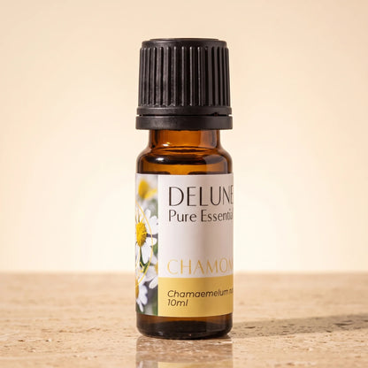 Delune Chamomile Roman Pure Essential Oil, 10ml amber glass bottle on warm travertine stone
