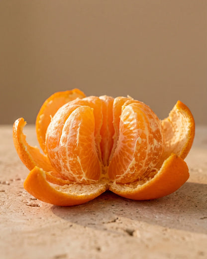 A freshly peeled mandarin with its segments glowing in warm light — the sweet, juicy citrus scent of Delune Mandarin Pure Essential Oil